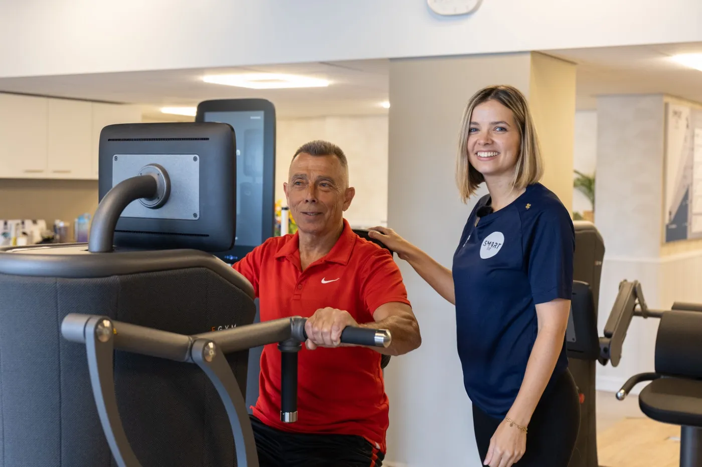 Trainer begeleidt een sporter op een EGYM-apparaat bij Smart Fit Boutique
