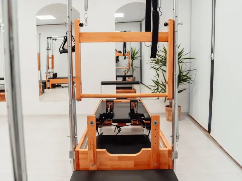 Reformer met toren in een lichte pilatesruimte (voorbeeldfoto)